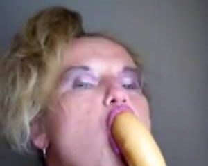 Kijk hoe diep de geile huisvrouw de dildo in haar mond steekt